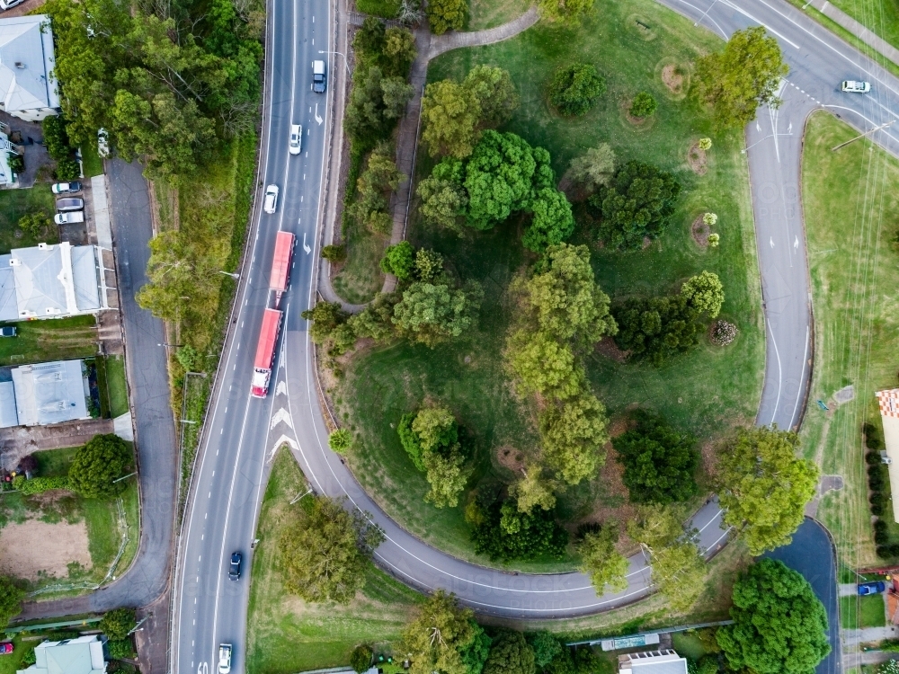 Semi truck on highway beside off ramp with park inside in town - Australian Stock Image