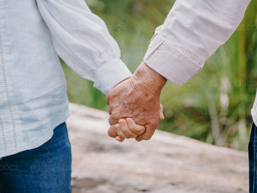 senior couple holding hands enjoying a healthy lifestyle in nature - Australian Stock Image