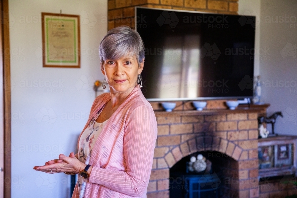 senior woman standing in her living room - Australian Stock Image