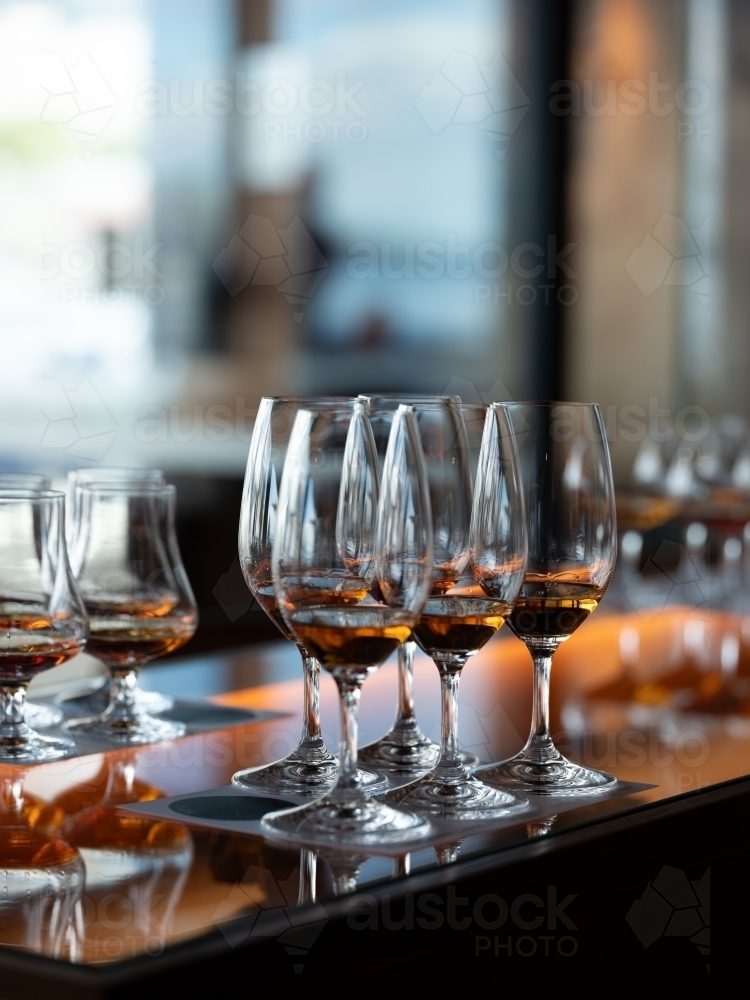 Series of glass wares filled with whisky for tasting - Australian Stock Image