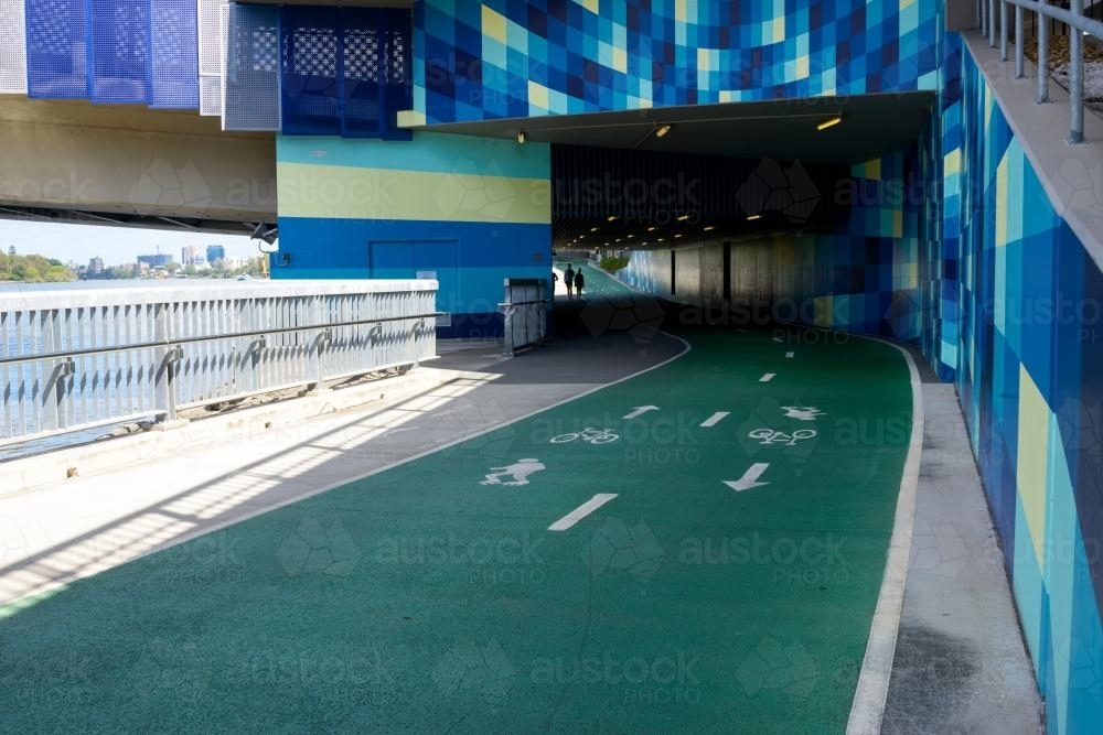 Shared bike and footpath with people silhouetted in background at end of underpass. - Australian Stock Image