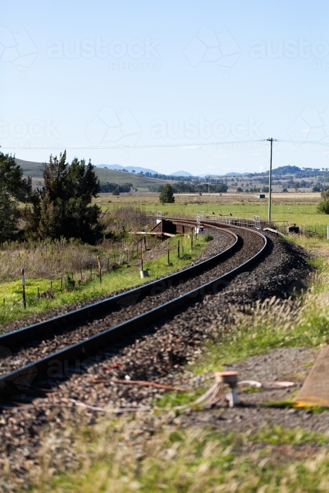 Sharp bend in railway train line track in country setting - Australian Stock Image