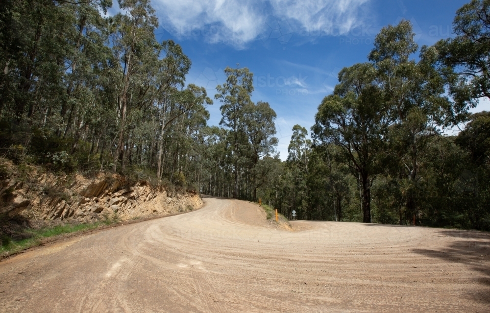 Sharp bend on unsealed mountain road - Australian Stock Image