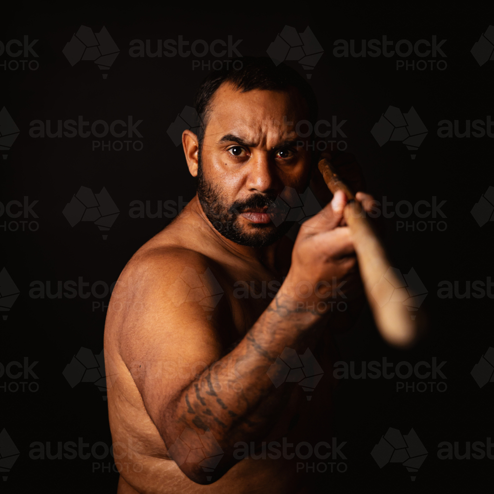Shirtless aboriginal man holding a wooden spear - Australian Stock Image
