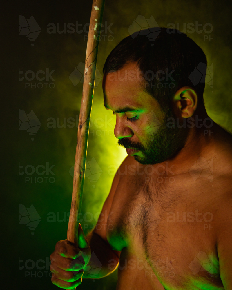 Shirtless aboriginal man holding a wooden spear - Australian Stock Image