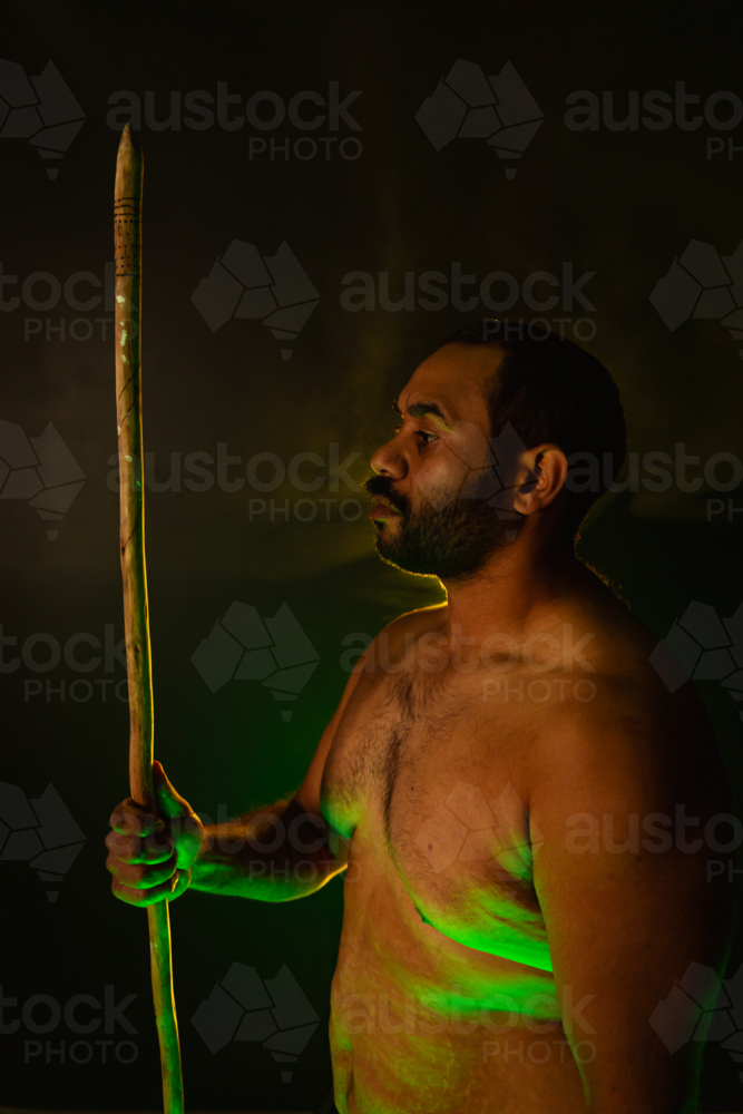 Shirtless aboriginal man holding a wooden spear - Australian Stock Image