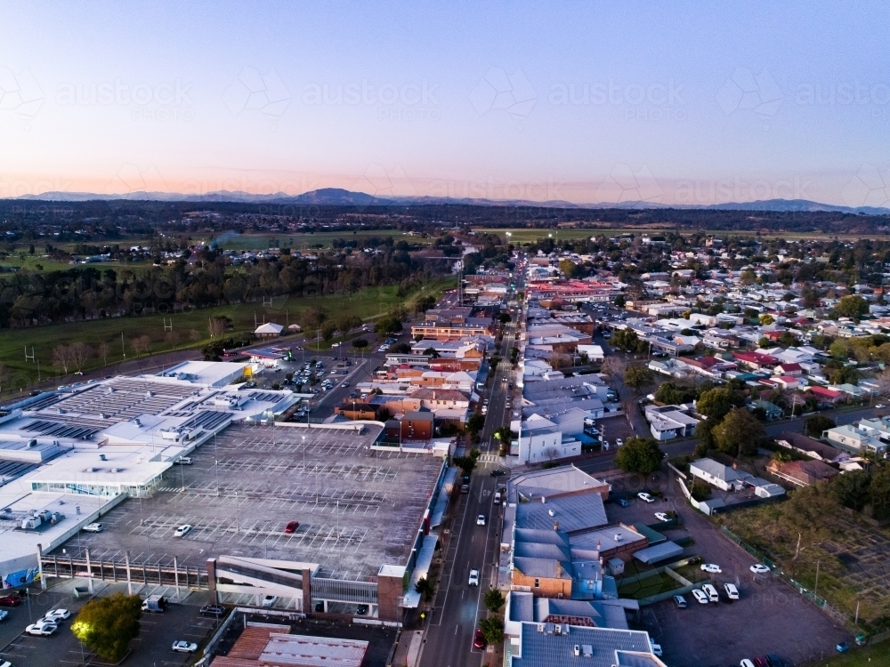 shopping centre carpark and main street in country town at dusk - Australian Stock Image