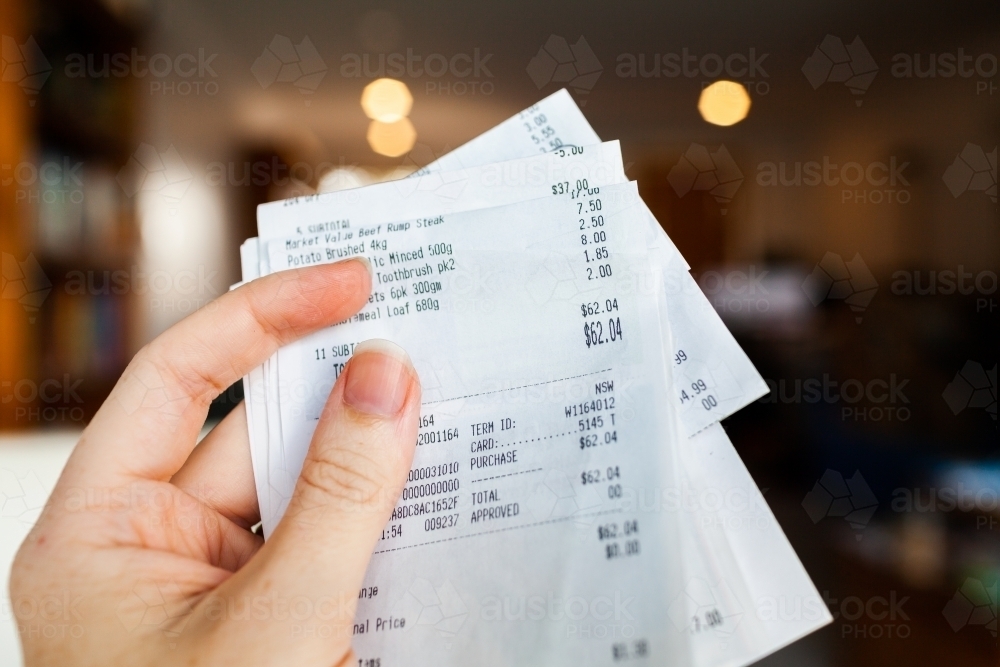 Shopping receipt held in hand of a woman - Australian Stock Image