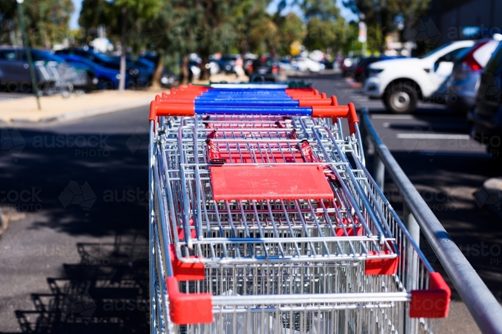 Shopping trolleys in an outdoor car park, blurred background. - Australian Stock Image