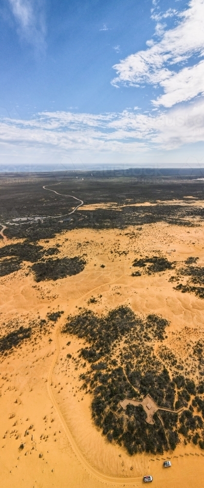 shot of an outback vertical shot near the ocean with green bushes on a sunny day with cloudy skies - Australian Stock Image