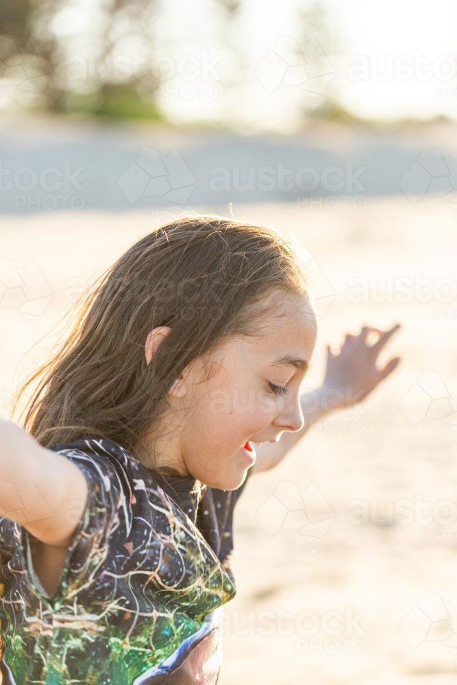 Side profile of Torres Strait Islander boy in sunshine at beach on windy day - Australian Stock Image