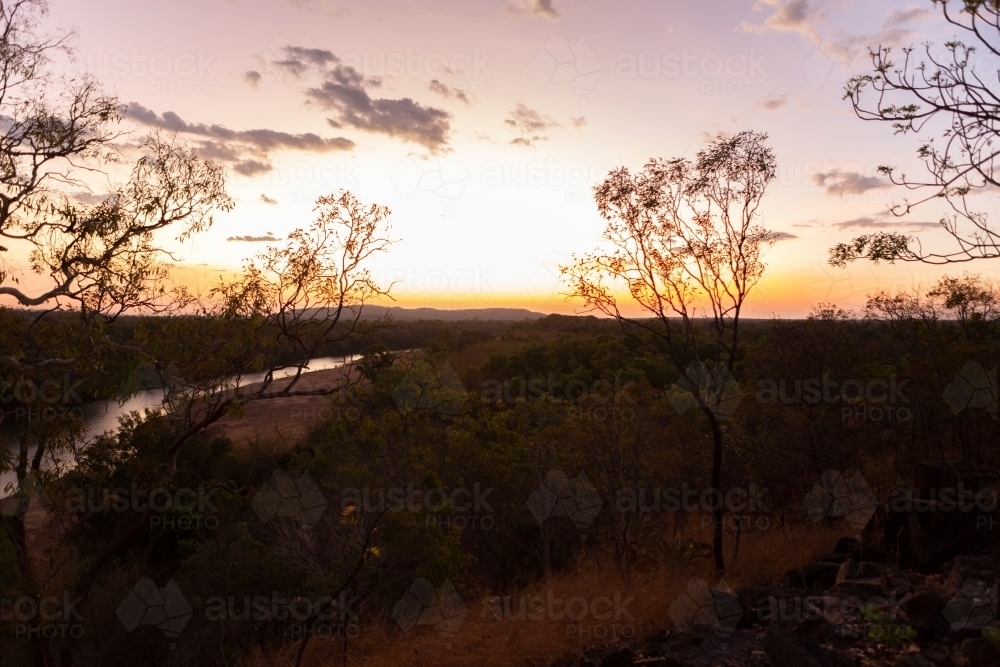 Side shot of an river with yellow skies approaching sunset - Australian Stock Image