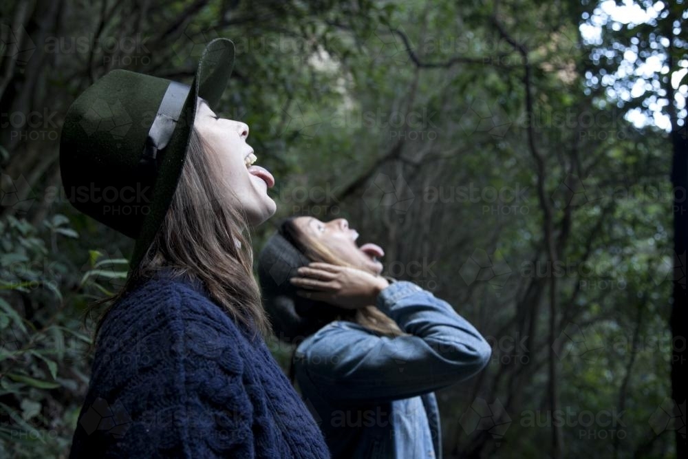 Side view of two women with tongues in the rain - Australian Stock Image