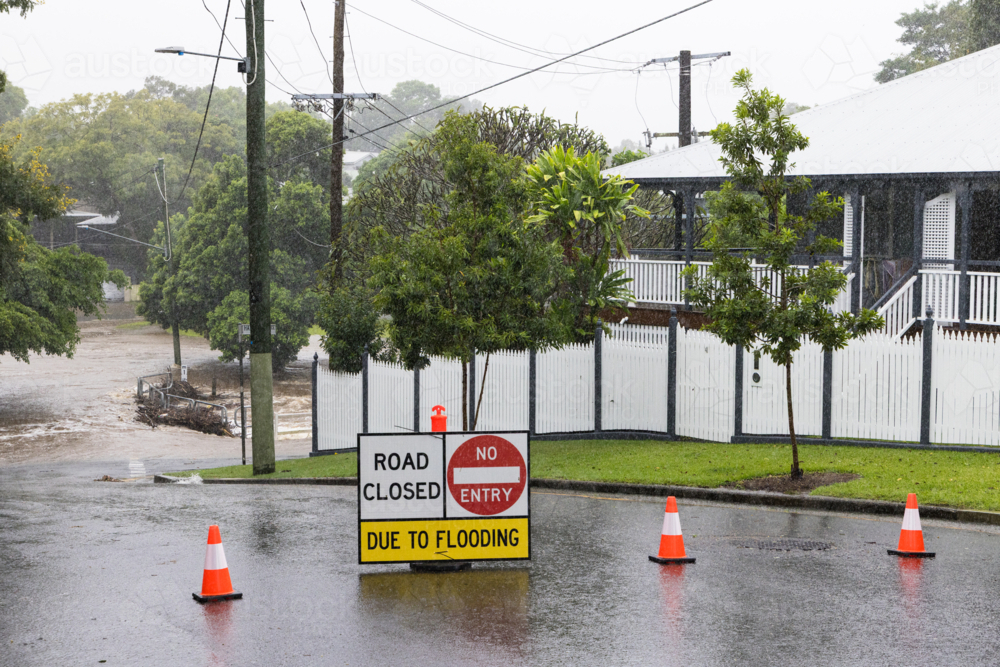 Signage across a flooded suburban road to stop traffic proceeding during a major rain event - Australian Stock Image