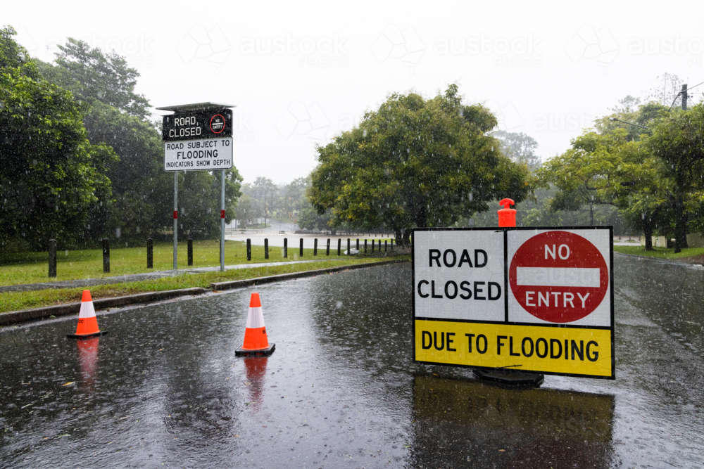 Signage on a road showing it is closed due to flooding in suburban Brisbane - Australian Stock Image