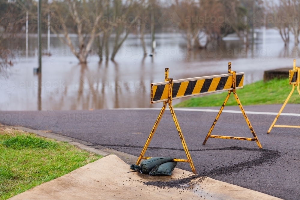 Signs blocking off road that is underwater during flood natural disaster - Australian Stock Image