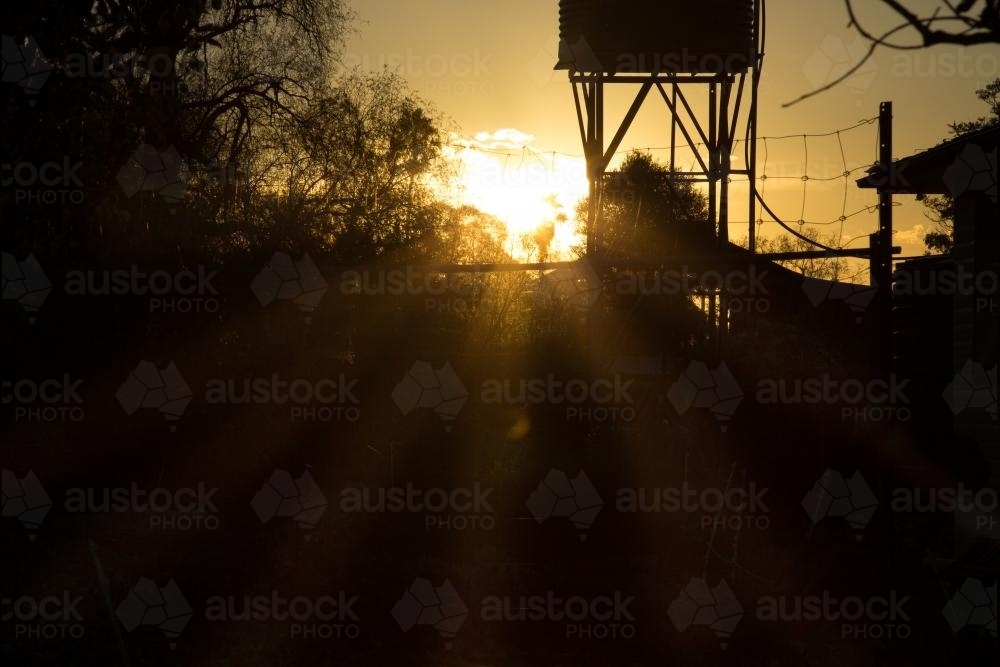 Silhouette of a rain water tank on a stand - Australian Stock Image