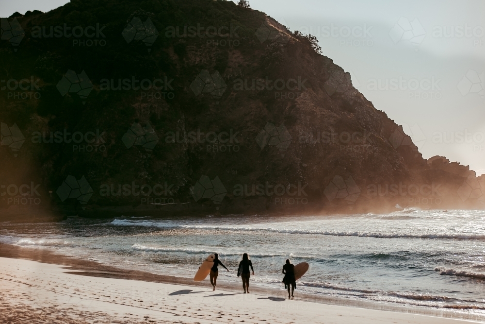 Silhouette of surfers on beach in early morning - Australian Stock Image