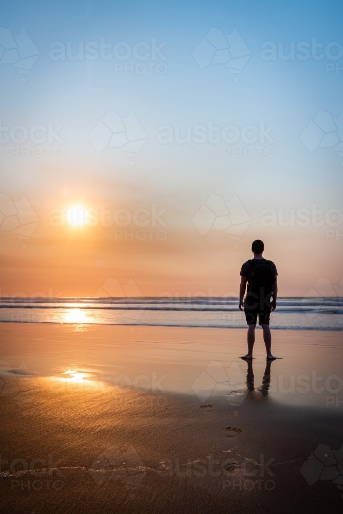 Silhouetted Figure Watching the Sunrise from a Great Ocean Road Beach - Australian Stock Image