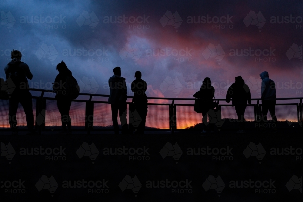 Silhouettes of tourists at Echo Point in Blue Mountains at sunset - Australian Stock Image