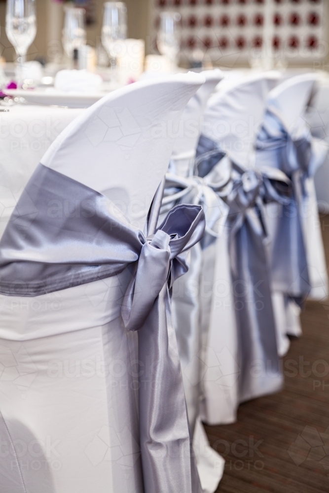 Image Of Silk Bows On White Chair Covers At A Wedding Reception