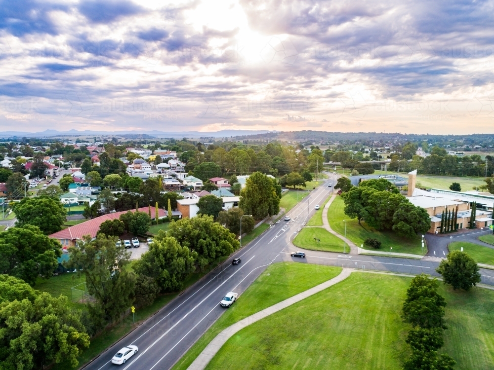 Single ray of light shining down over town of singleton on summer evening - Australian Stock Image