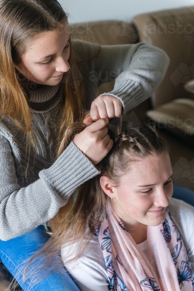 sister braiding hair - Australian Stock Image