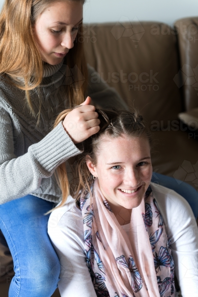 sister braiding hair - Australian Stock Image