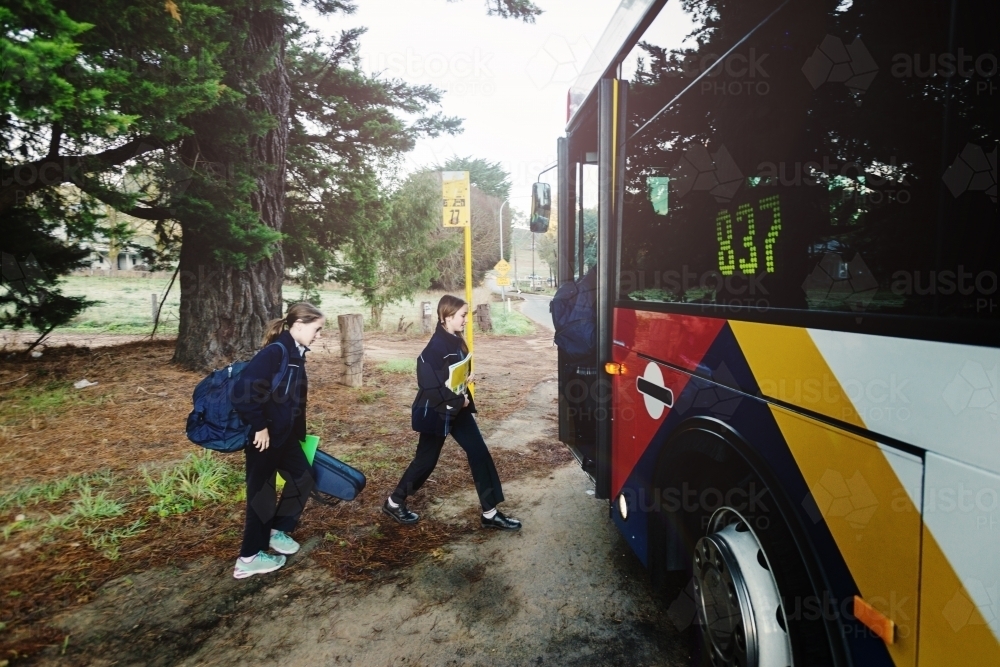 sisters getting on the morning school bus - Australian Stock Image