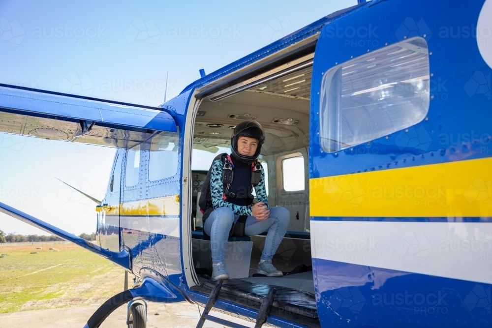 skydiver wearing helmet sitting in plane with door open - Australian Stock Image