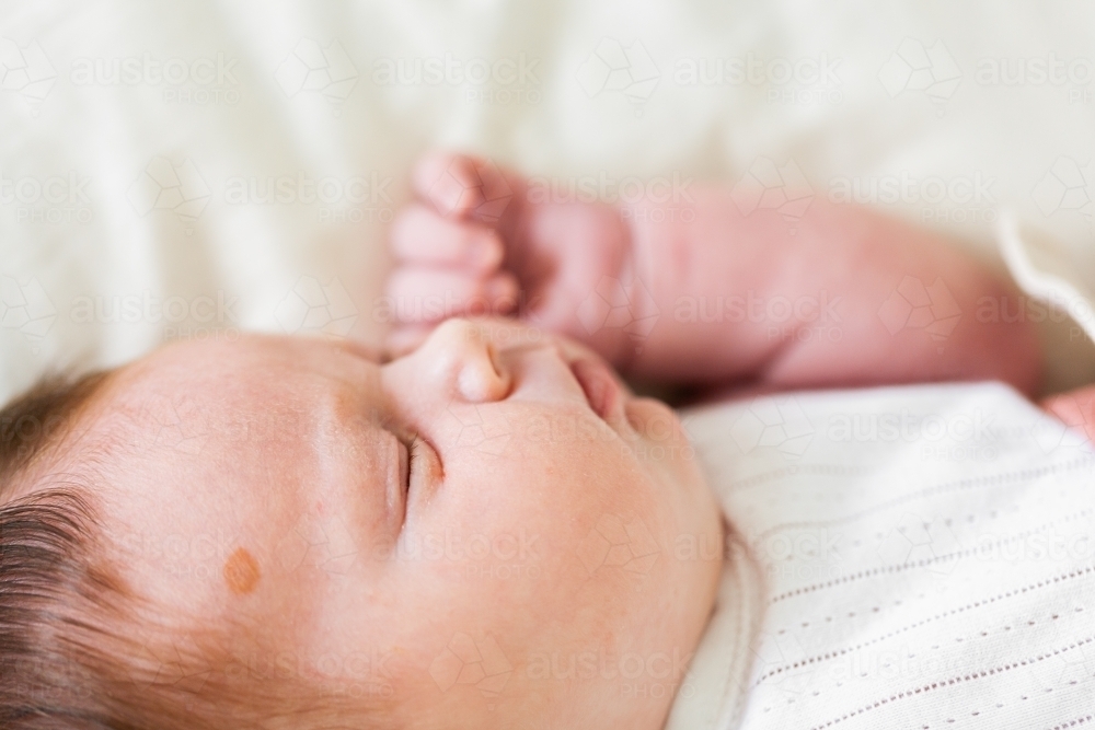 Sleeping newborn baby on white with lots of hair - Australian Stock Image