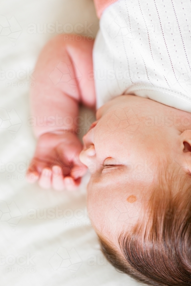 Sleeping newborn baby on white with lots of hair - Australian Stock Image