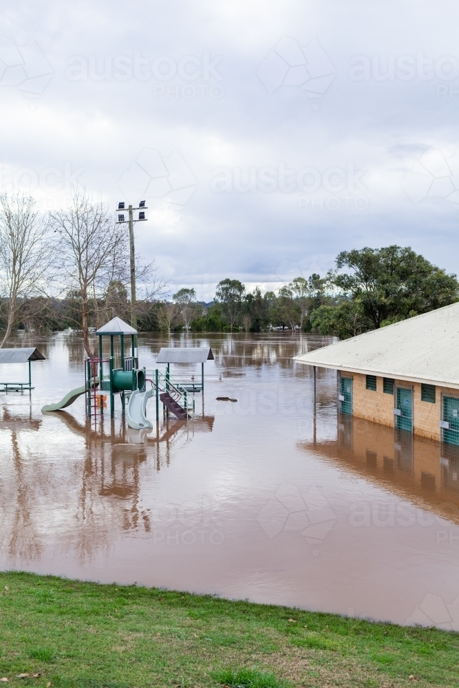 Slippery dip slide and playground at park under water during flood - Australian Stock Image