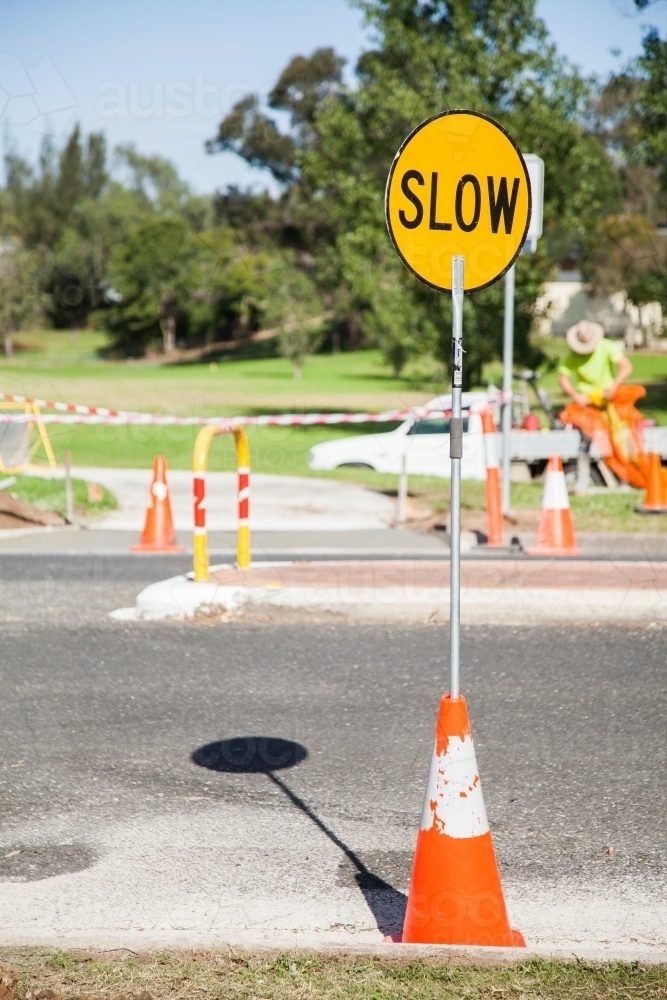 Slow road work lollipop sign in road cone - Australian Stock Image