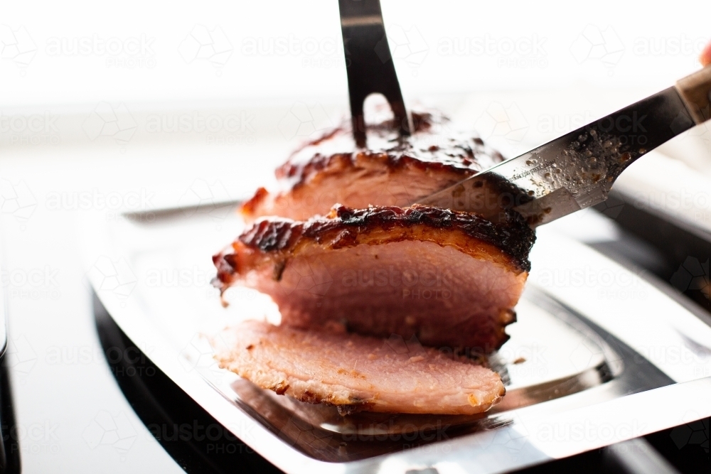 small baked glazed ham being sliced to serve - Australian Stock Image