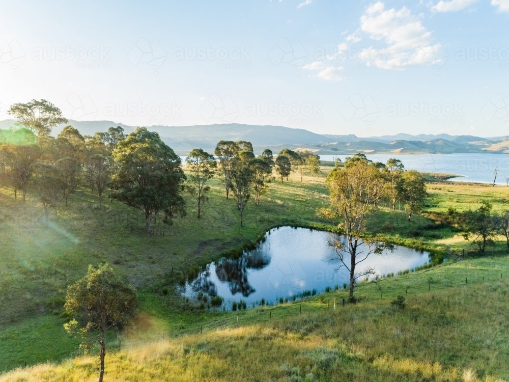 Small farm dam in paddock beside Lake St Clair water supply dam - Australian Stock Image