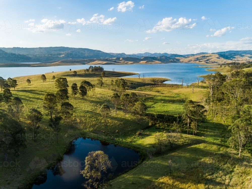 Small farm dam in paddock beside Lake St Clair water supply dam - Australian Stock Image