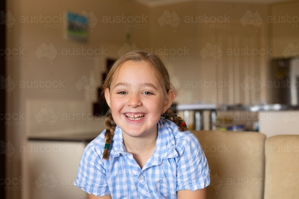 smiling child at home with toothy smile - Australian Stock Image