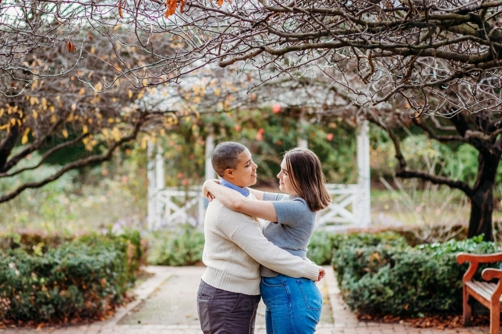 Smiling lgbtqi couple looking at each other while hugging - Australian Stock Image