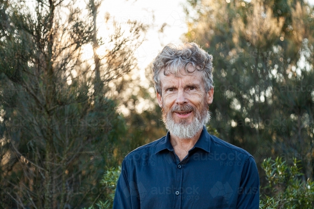 Smiling man with scruffy beard outside in the bush - Australian Stock Image