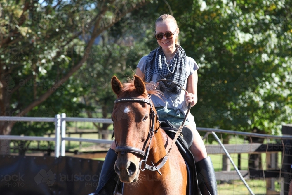 Smiling woman riding horse - Australian Stock Image