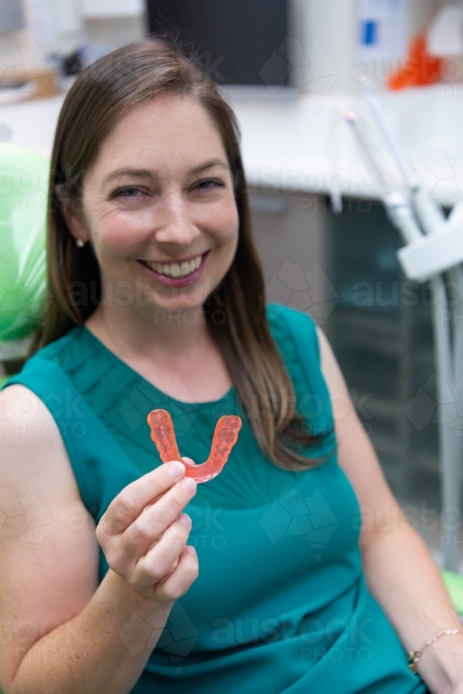 Smiling women holding dental splint - Australian Stock Image