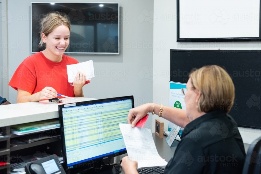 Smiling women in dental reception room after appointment - Australian Stock Image