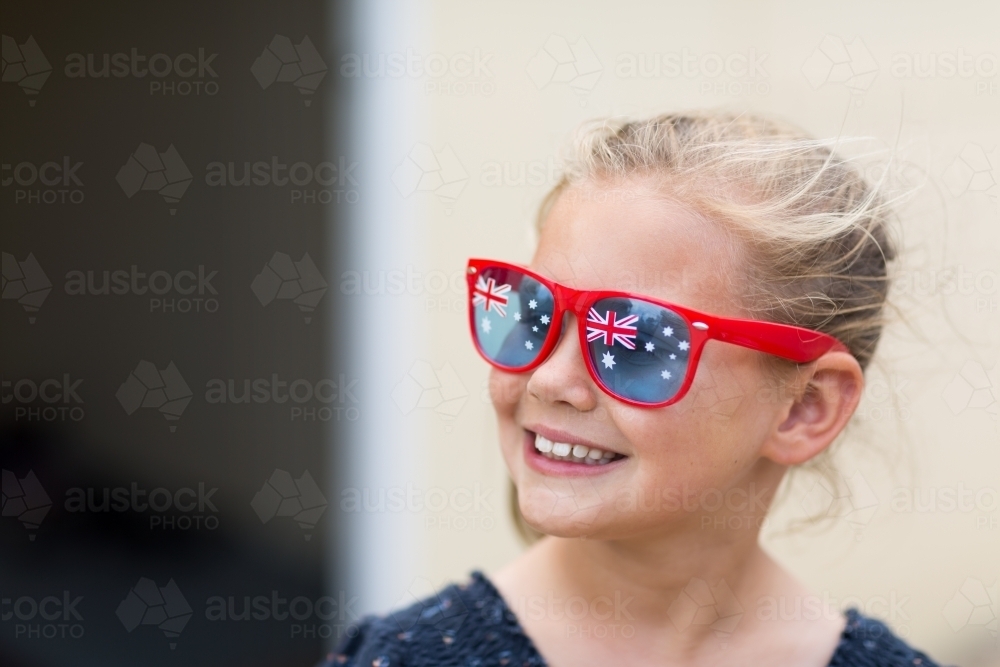 Smiling young girl wearing Australian Flag sunglasses - Australian Stock Image