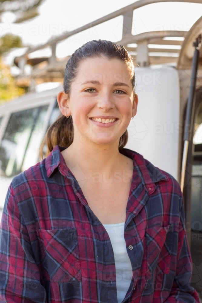 Smiling young woman wearing flannel shirt - Australian Stock Image