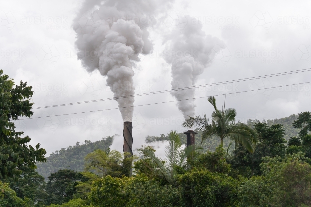 Smoke billowing out of smokestacks at sugar refinery - Australian Stock Image