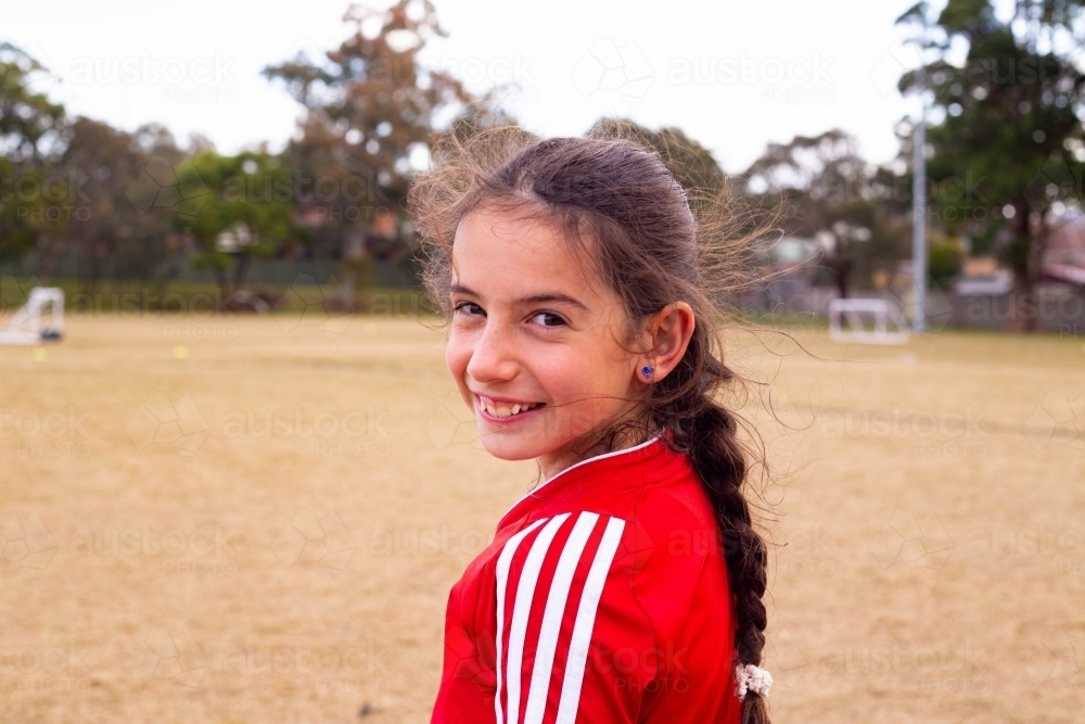 Soccer player female turning to smile with copy space - Australian Stock Image