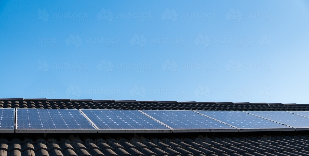 Solar panels installed on roof, blue sky background. Green clean energy - Australian Stock Image