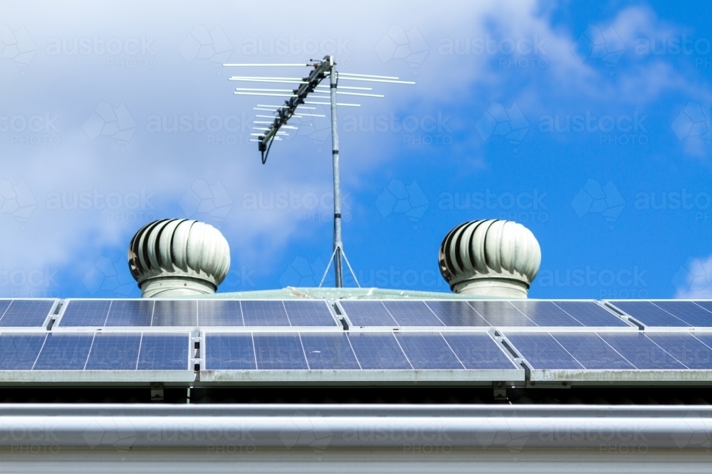 Solar panels, tv antenna, and two roof whirly birds. - Australian Stock Image