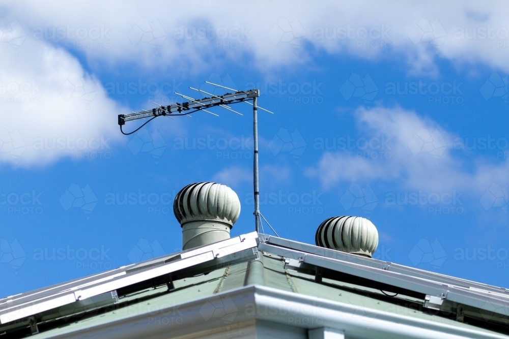 Solar panels, tv antenna, and two roof whirly birds. - Australian Stock Image